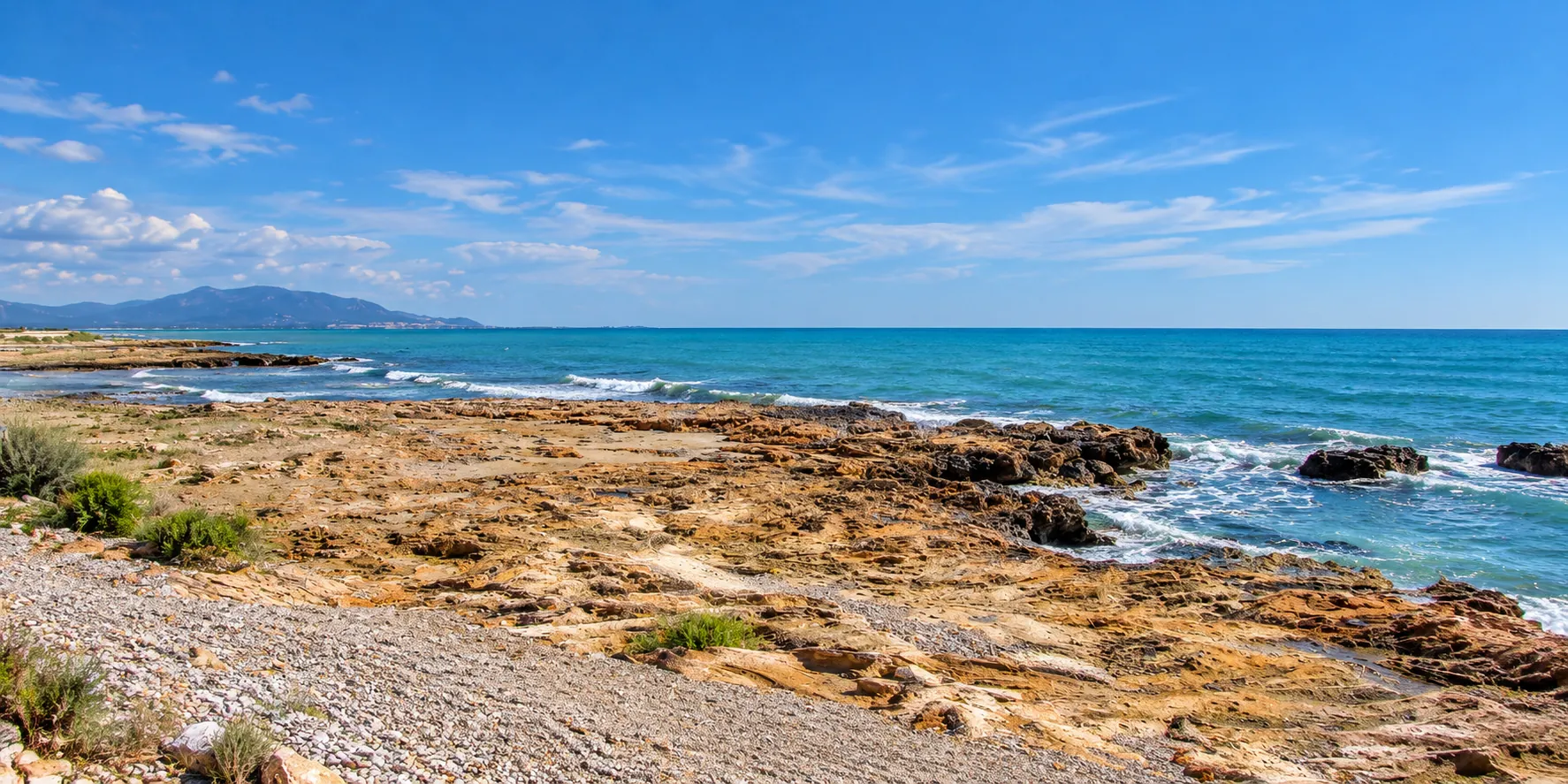 Costa mediterránea de rocas junto al mar azul