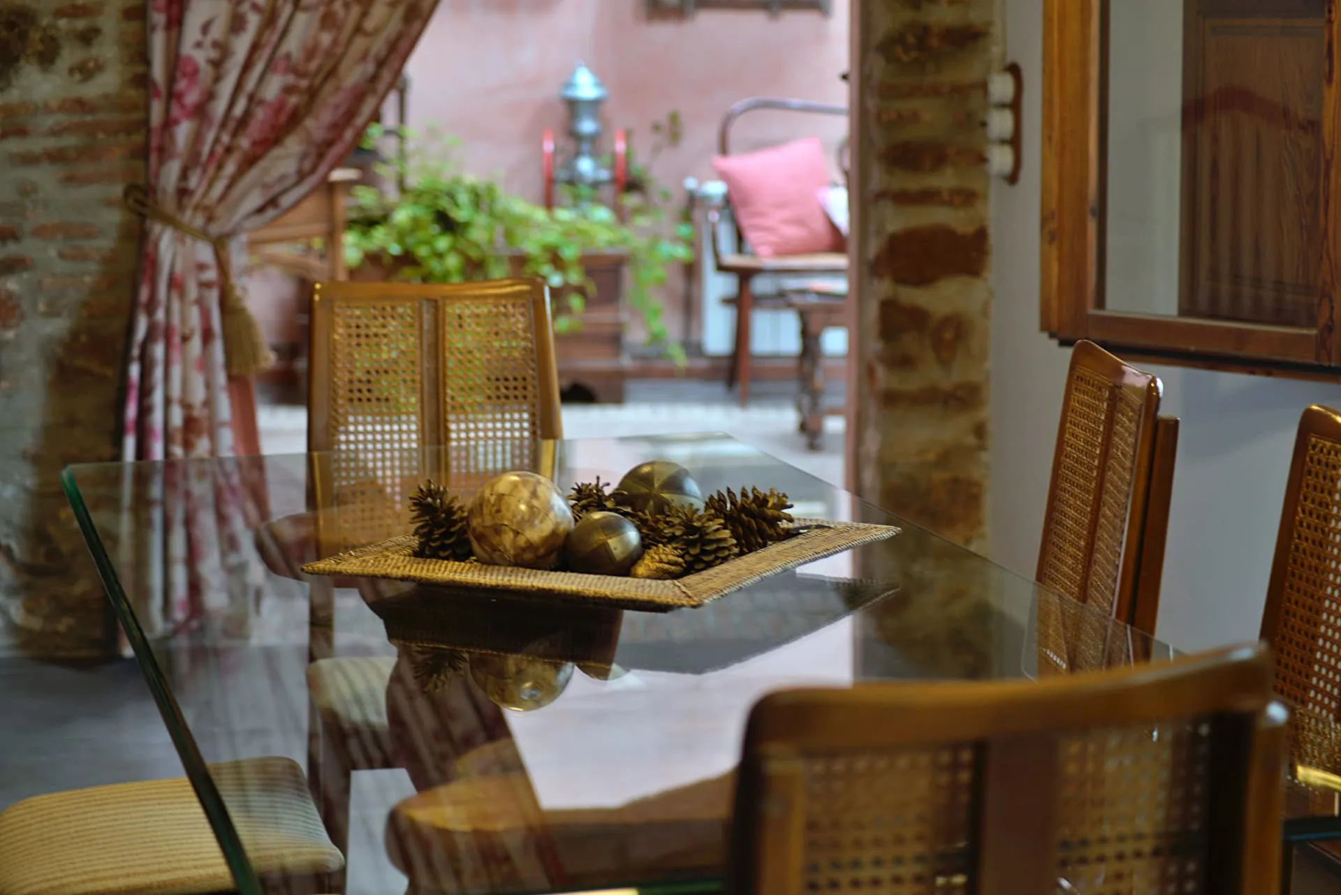 Mesa de cristal del comedor con sillas de rejilla y centro decorativo